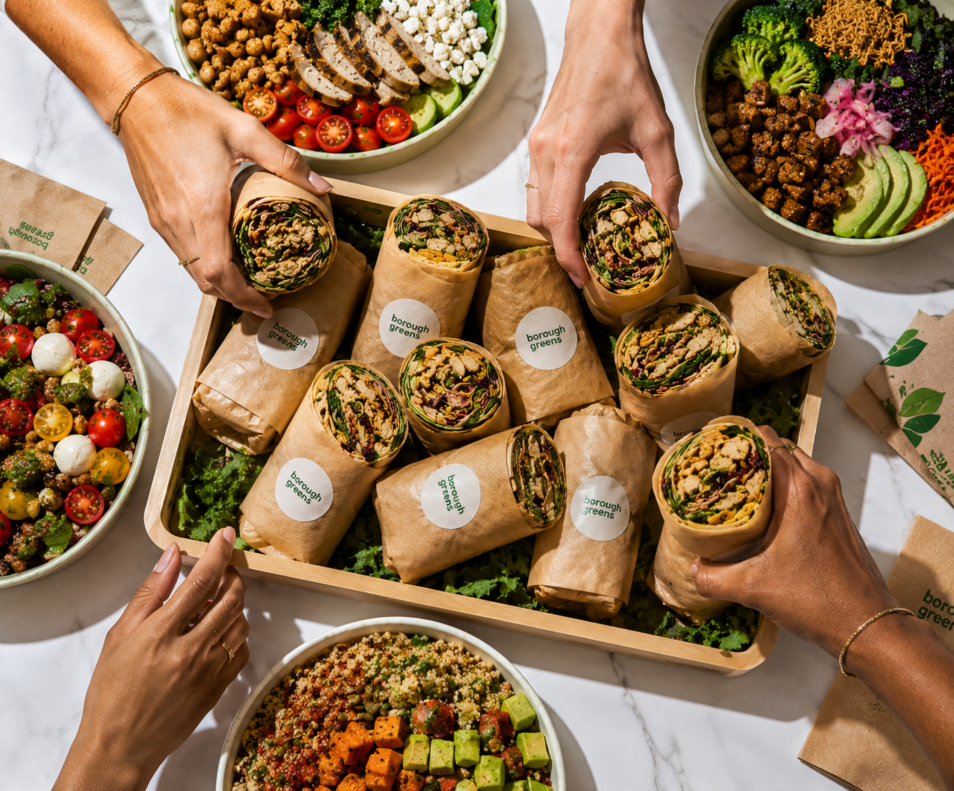 Borough Greens wraps, salads and grain bowls spread on a marble table